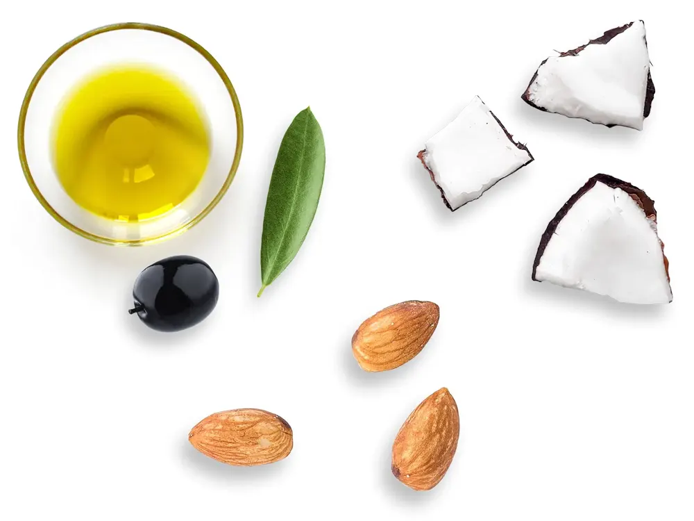 Un petit pot d'huile d'olive avec quelques amandes et morceaux de coco dispersés.