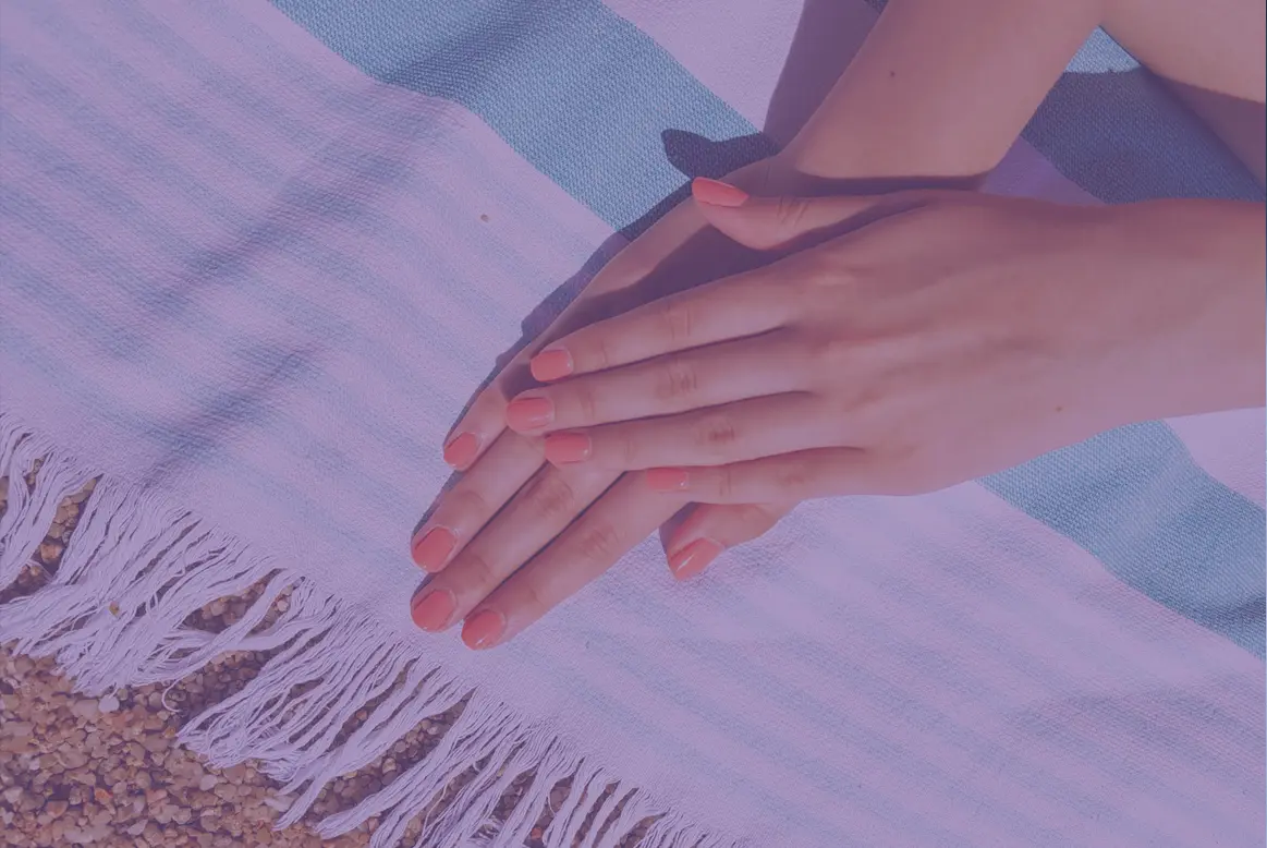 Deux mains au soleil, sur une serviette de plage